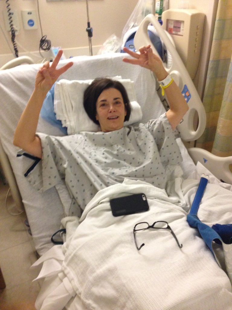 Pre operation prep for shoulder surgery, giving peace sign with both hands.